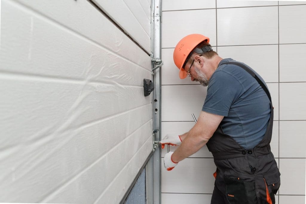 Worker installing equipment on wall