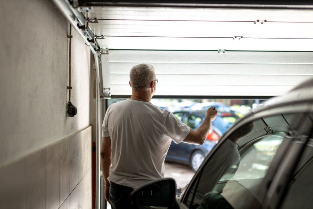 Man opening garage door, looking outside